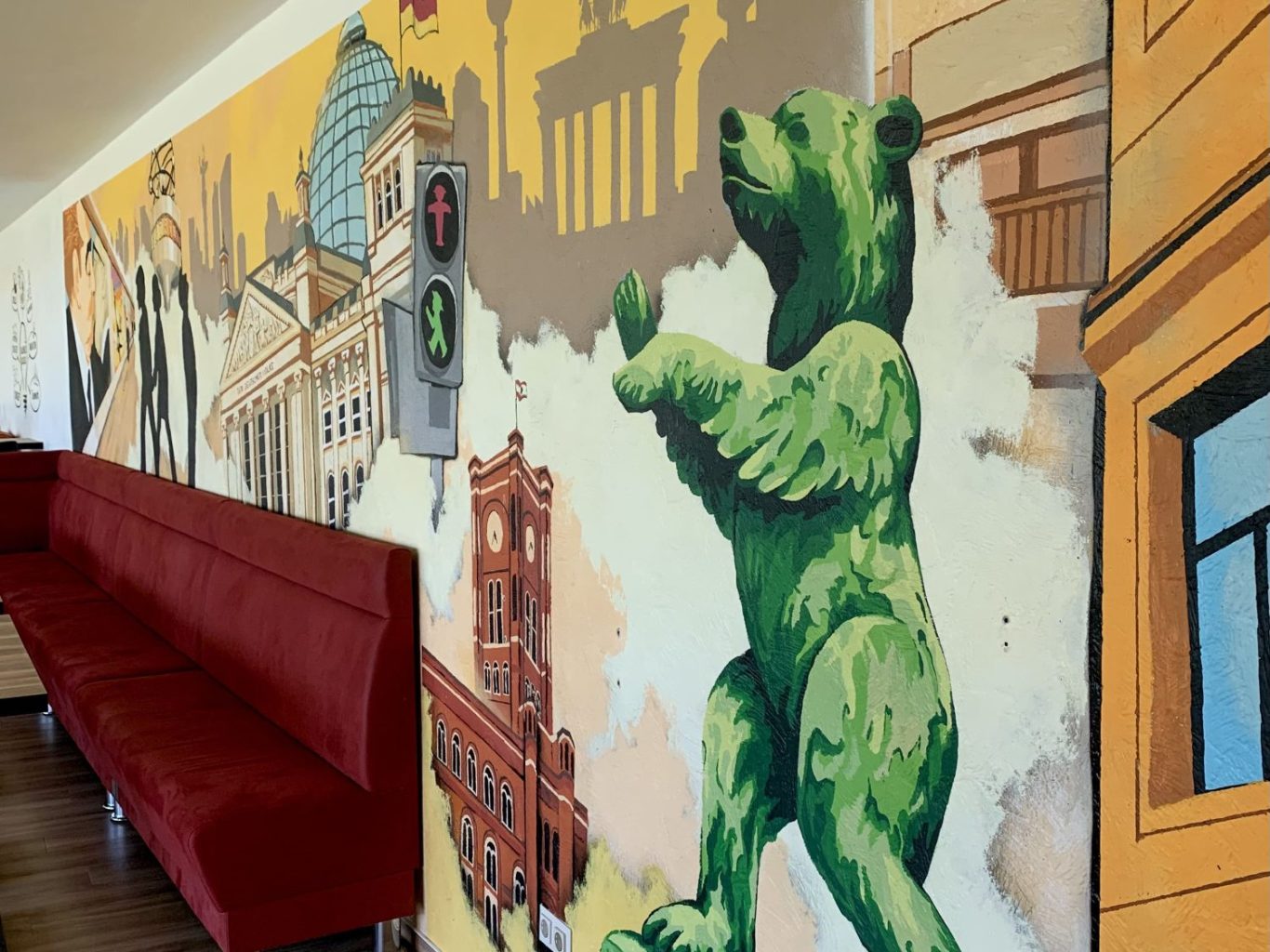 Fitnessraum Wandgestaltung im Graffiti Streetart Style Buntes, detailreiches Wimmelbild-Graffiti im Fitnessraum in Troisdorf mit zentralem gelbem Logo