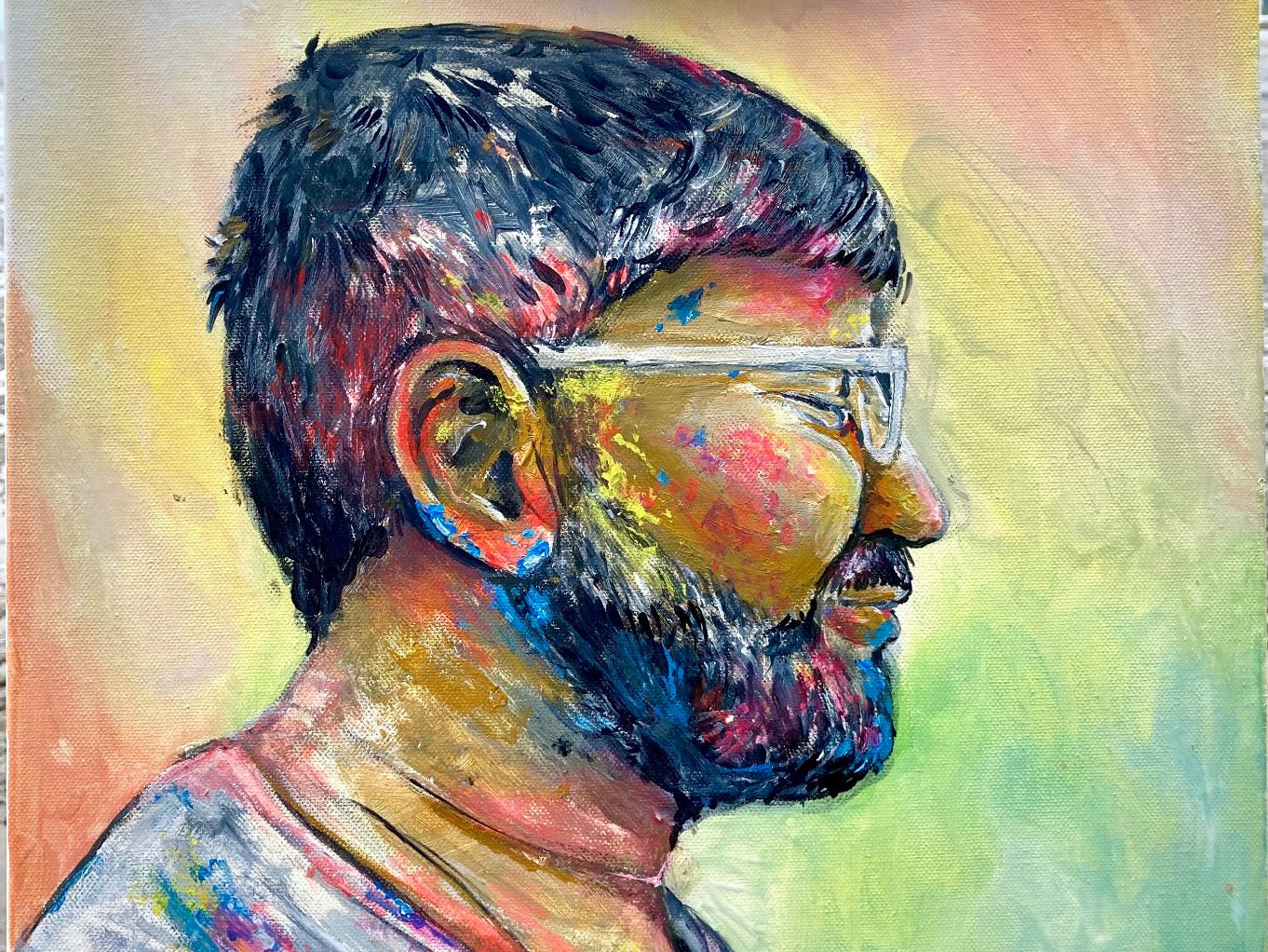 Farbenfrohes Mixed-Media-Portrait eines bärtigen, mit bunten Farben bedecken Mannes im Profil